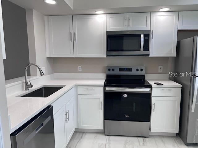 A kitchen with white cabinets, stainless steel appliances, and light-colored countertops — 1225 GARDEN ISLE COURT, ORLANDO, FL