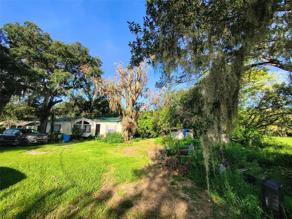 A mobile home sits on a grassy lot surrounded by large trees with Spanish moss — 3609 MAXWELL ROAD, PLANT CITY, FL