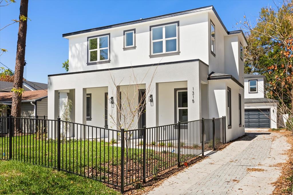 A modern two-story white house with a black metal fence and a paved driveway — 1315 E HARDING STREET, ORLANDO, FL
