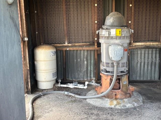 A large industrial water pump and a pressure tank sit inside a fenced enclosure — BAGLEY ROAD, HAINES CITY, FL
