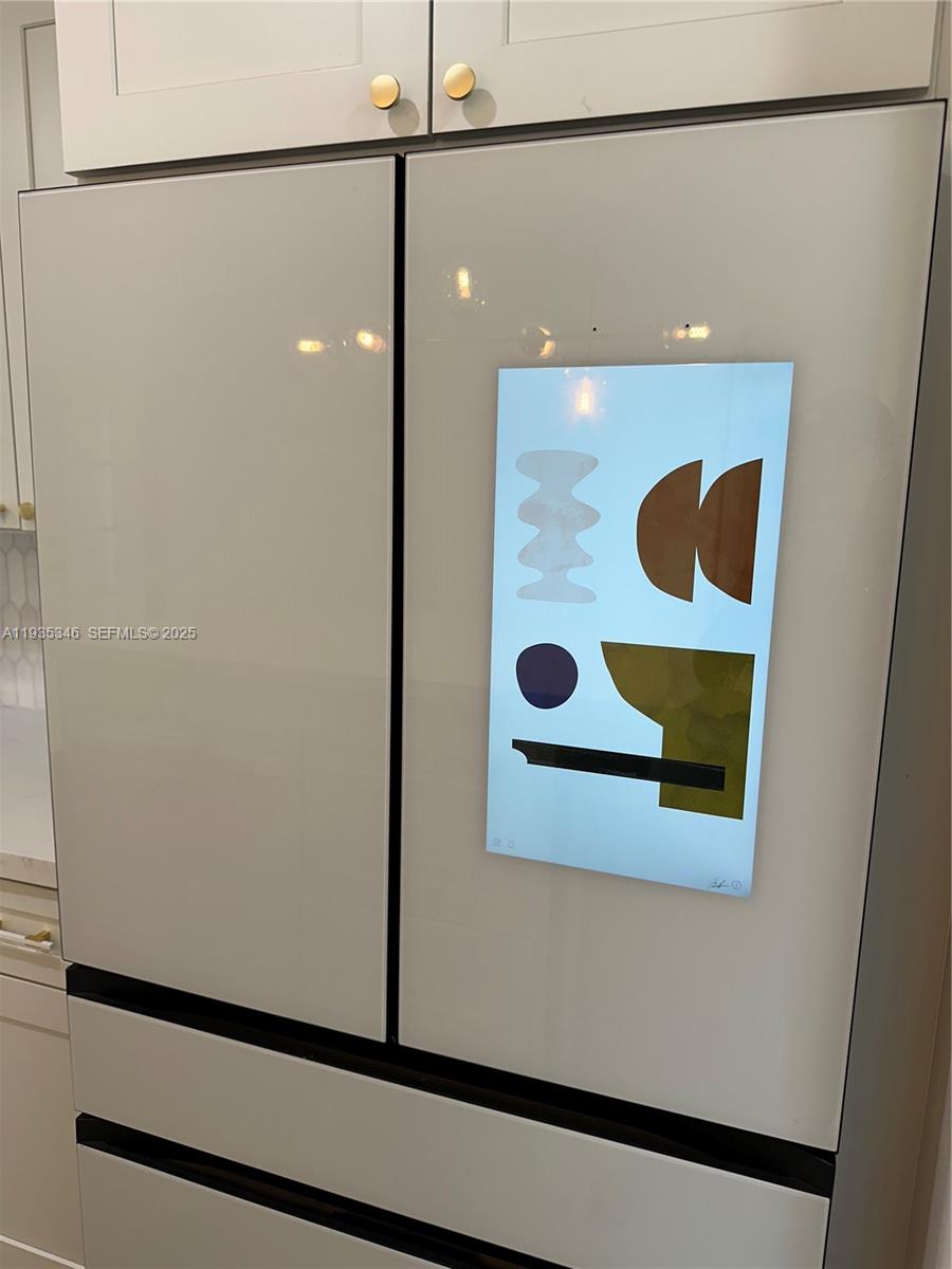 A modern white refrigerator with a digital display screen is built into kitchen cabinetry — 708 SE 3rd Ave Ext # 201, Hallandale Beach FL 33009, HALLANDALE BEACH, FL
