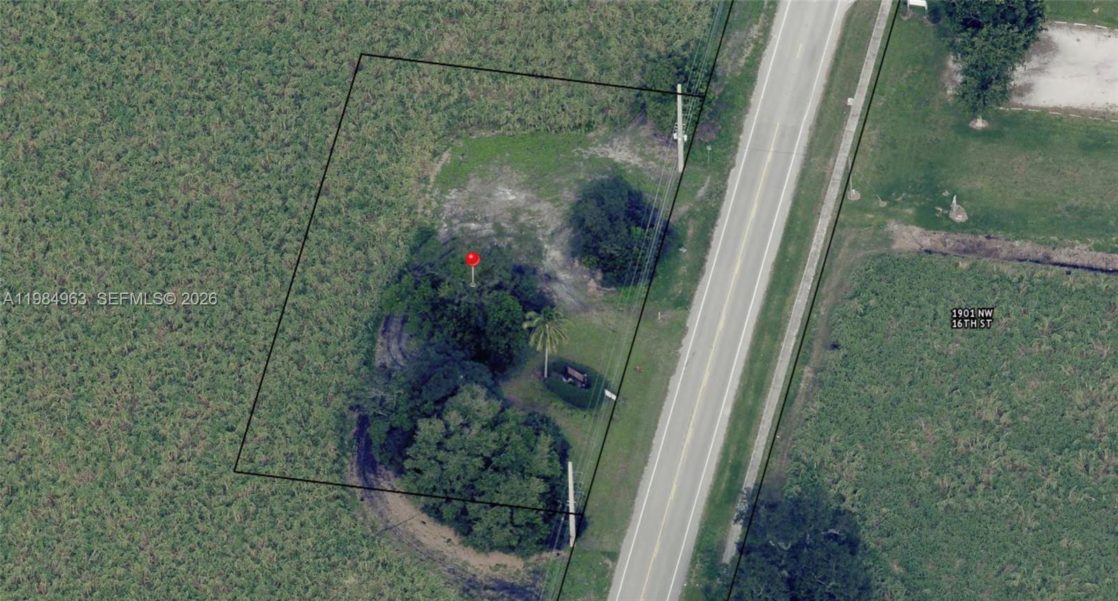 This aerial view shows a rectangular plot of land with trees and a small structure — N State Road 715, Belle Glade FL 33430, BELLE GLADE, FL
