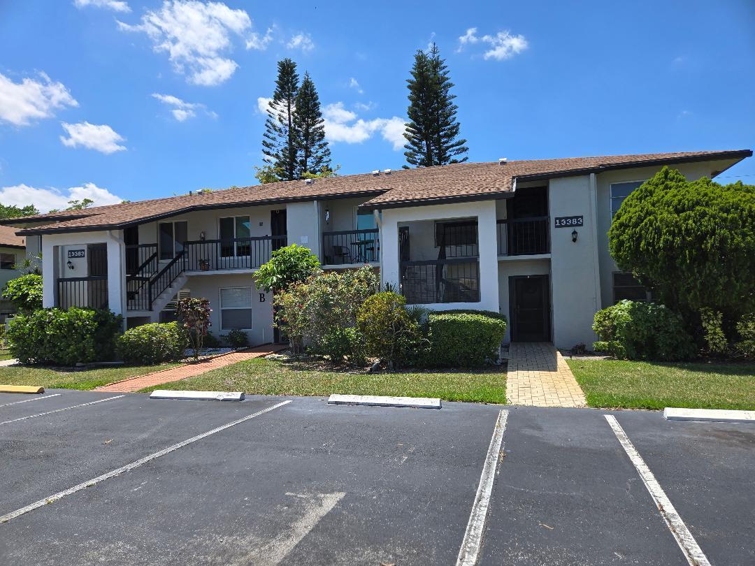 A two-story apartment building with a brown shingled roof and a paved parking lot — 13383 Pineapple Palm Court, Delray Beach FL 33484, DELRAY BEACH, FL