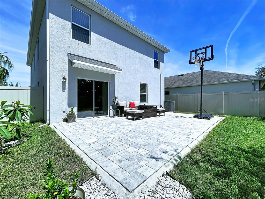 The exterior view shows a two-story house with a paved patio and basketball hoop — 16599 SECRET MEADOW DRIVE, ODESSA, FL