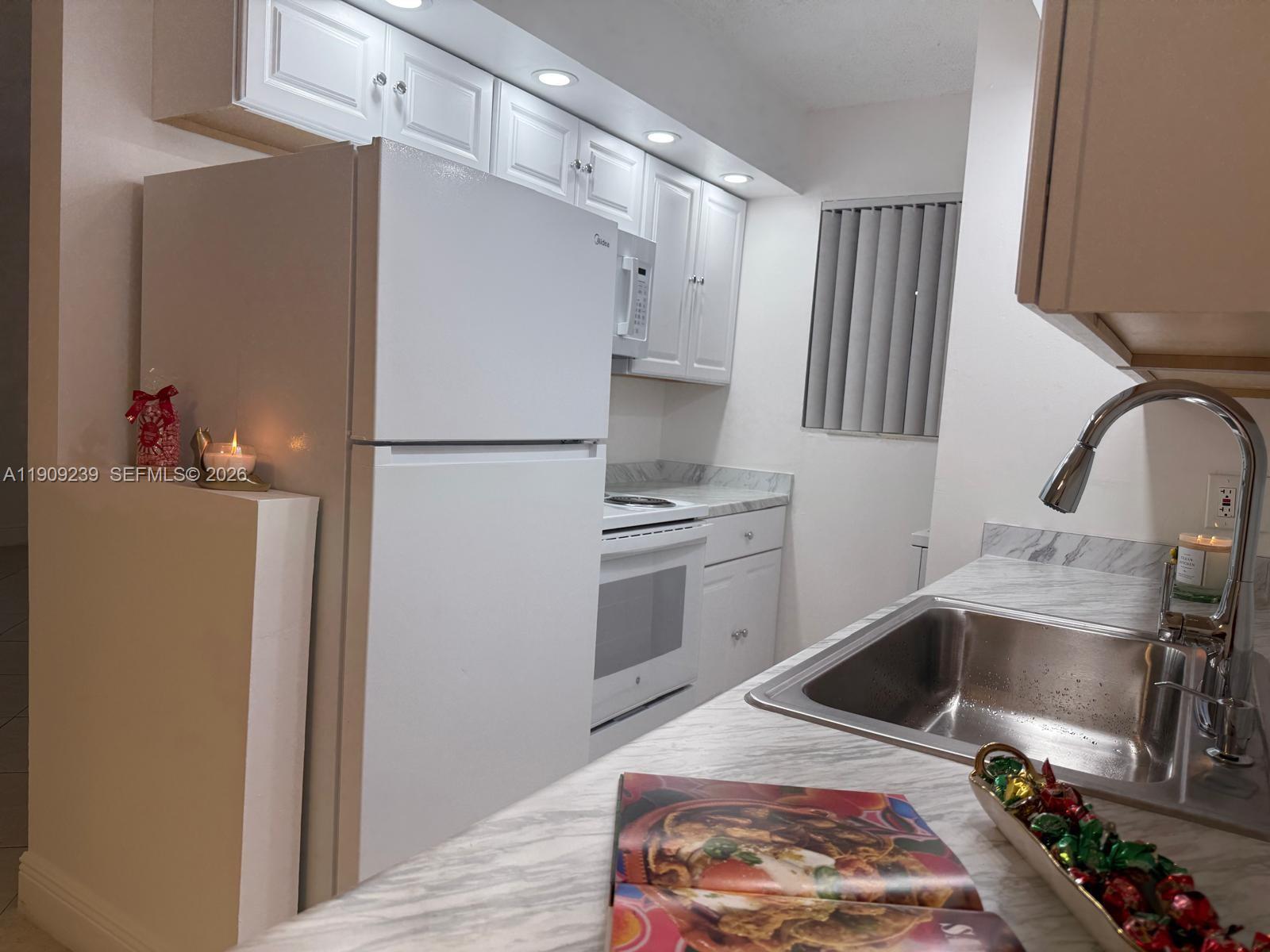 A two-story apartment building exterior features a ground-floor screened patio outlined in red — 523 Trace Cir # 105, Deerfield Beach FL 33441, DEERFIELD BEACH, FL