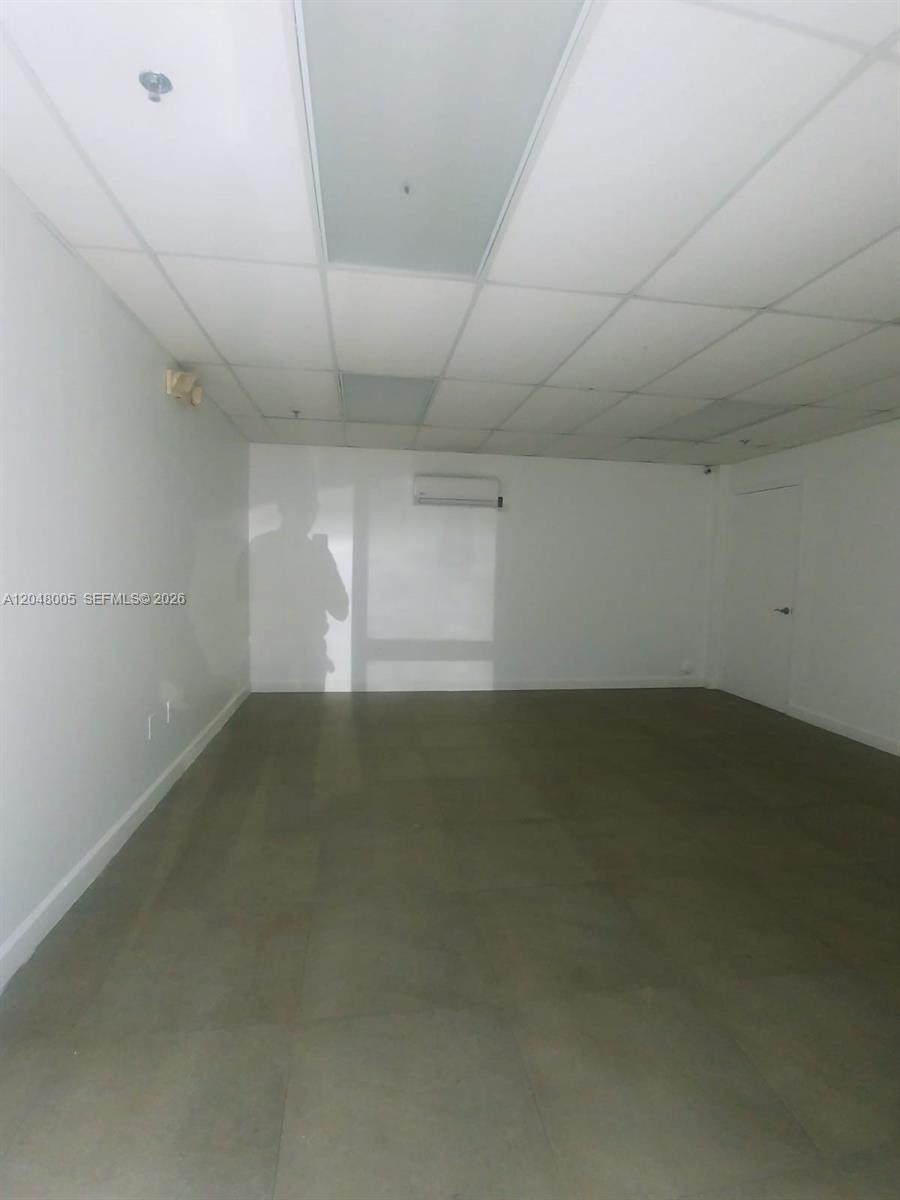 An empty office space features white walls, a drop ceiling, and gray tiled flooring — 2365 NW 70th Ave 18, Miami FL 33122, MIAMI, FL
