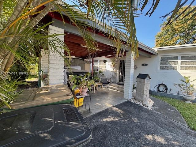 A covered patio area features a concrete floor, brick columns, and a view of the yard — 15 NE 130th St, North Miami FL 33161, NORTH MIAMI, FL