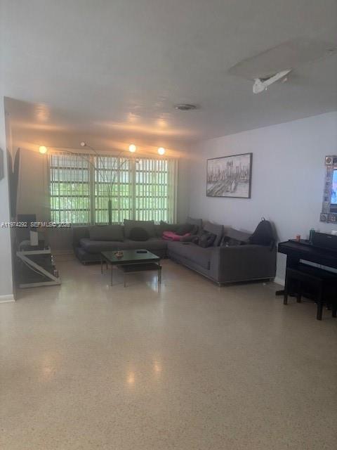 A living room features a large gray sectional sofa, a coffee table, and a piano — 15 NE 130th St, North Miami FL 33161, NORTH MIAMI, FL