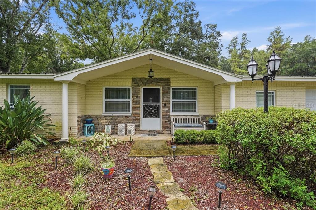 A single-story house with a yellow brick exterior, stone accents, and a stone walkway — 3500 OLD KEYSTONE ROAD, TARPON SPRINGS, FL