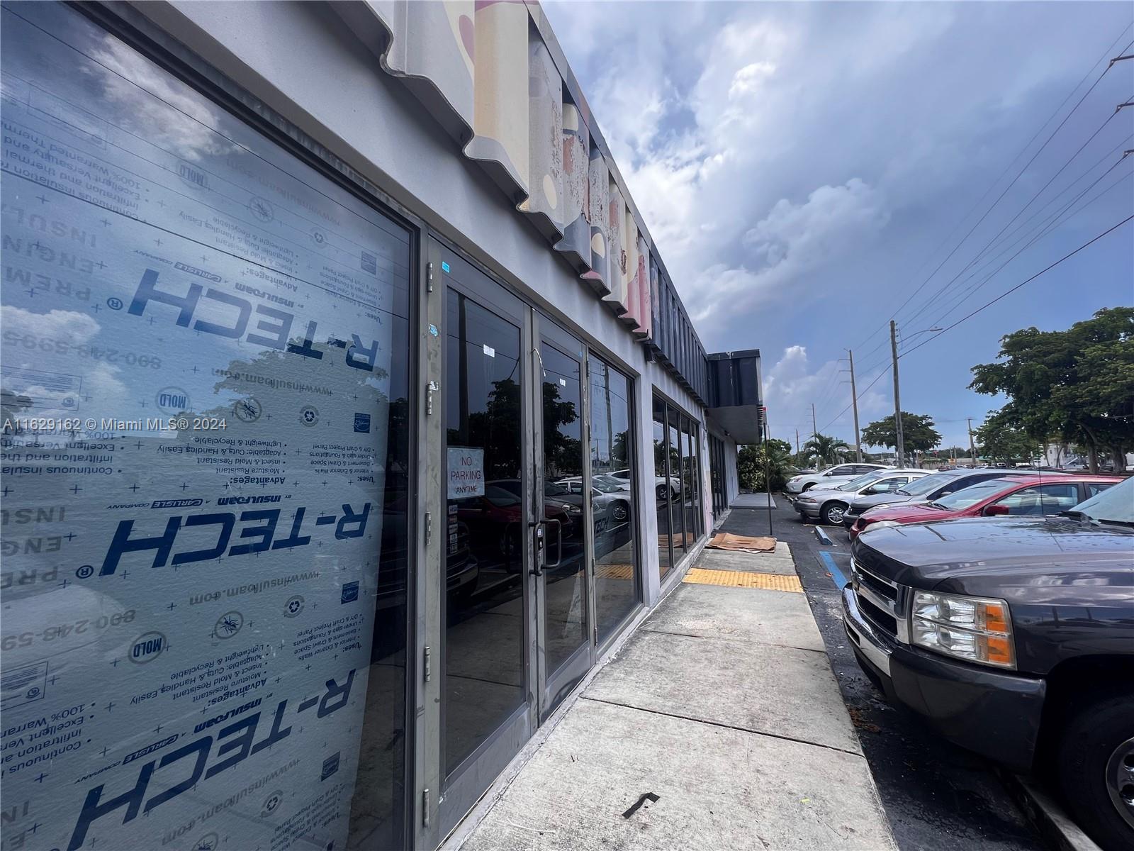 The exterior of a commercial building features glass doors and windows covered with insulation panels — 1100 S Dixie Hwy, Hollywood FL 33020, HOLLYWOOD, FL