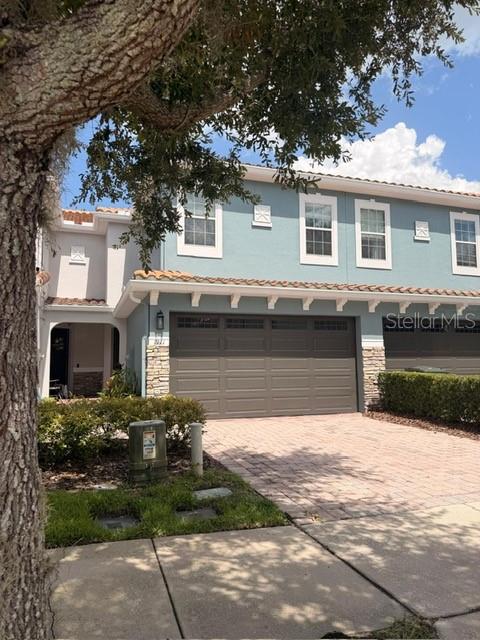 A two-story light blue house features a two-car garage and a paved driveway — 1911 SILVERWEED WAY, OVIEDO, FL
