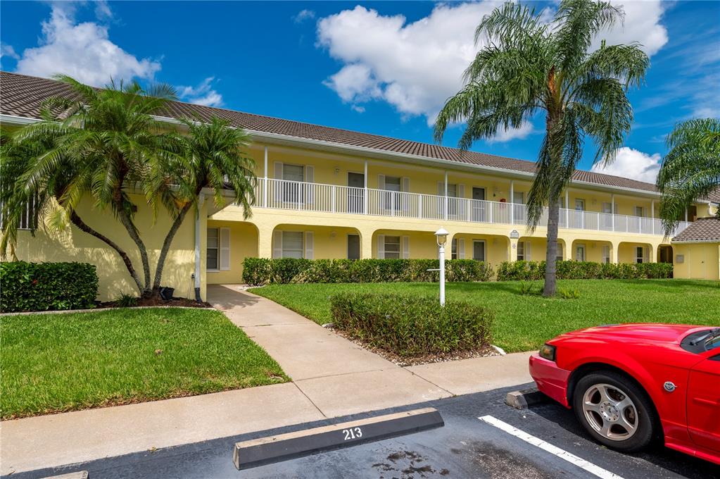 A two-story yellow apartment building with a white balcony and palm trees in front — 4000 BAL HARBOR BOULEVARD UNIT 223, PUNTA GORDA, FL