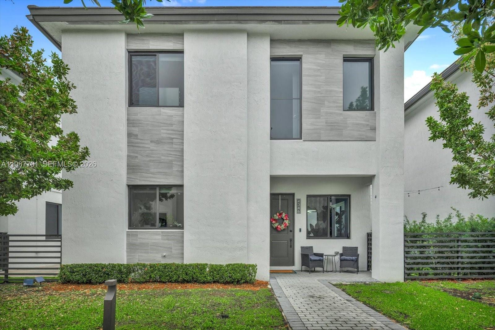 A two-story modern house features a white stucco facade with grey tile accents and landscaping — 4346 NW 81st Ave, Doral FL 33166, DORAL, FL