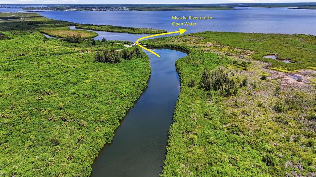 An aerial view shows a river flowing into a large body of open water — 15484 MARGO CIRCLE, PORT CHARLOTTE, FL