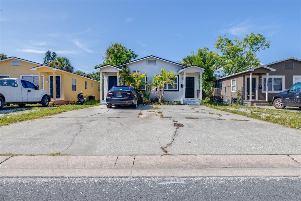 A single-story duplex with a shared concrete driveway sits between two neighboring houses — 2834 & 2836 FREEMONT TERRACE S, ST PETERSBURG, FL