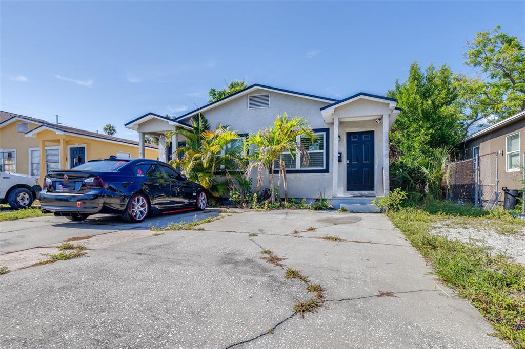 A single-story house with a concrete driveway, a black car, and palm trees in front — 2834 & 2836 FREEMONT TERRACE S, ST PETERSBURG, FL