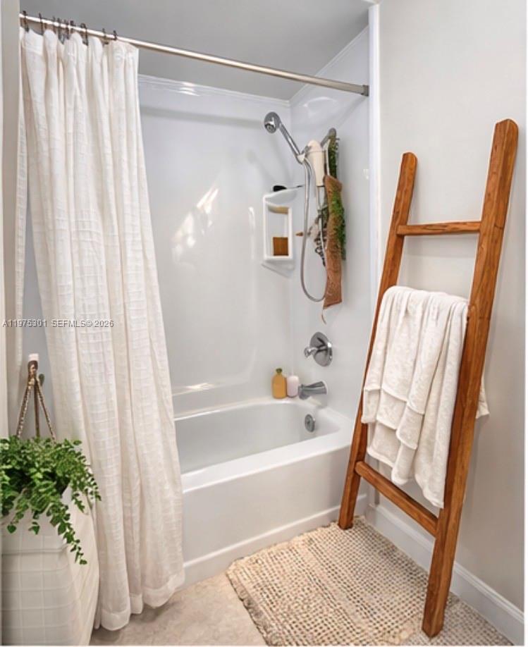 A bathroom features a white bathtub and shower surround, a wooden towel ladder, and curtains — 3301 NE 5th Ave # 519, Miami FL 33137, MIAMI, FL