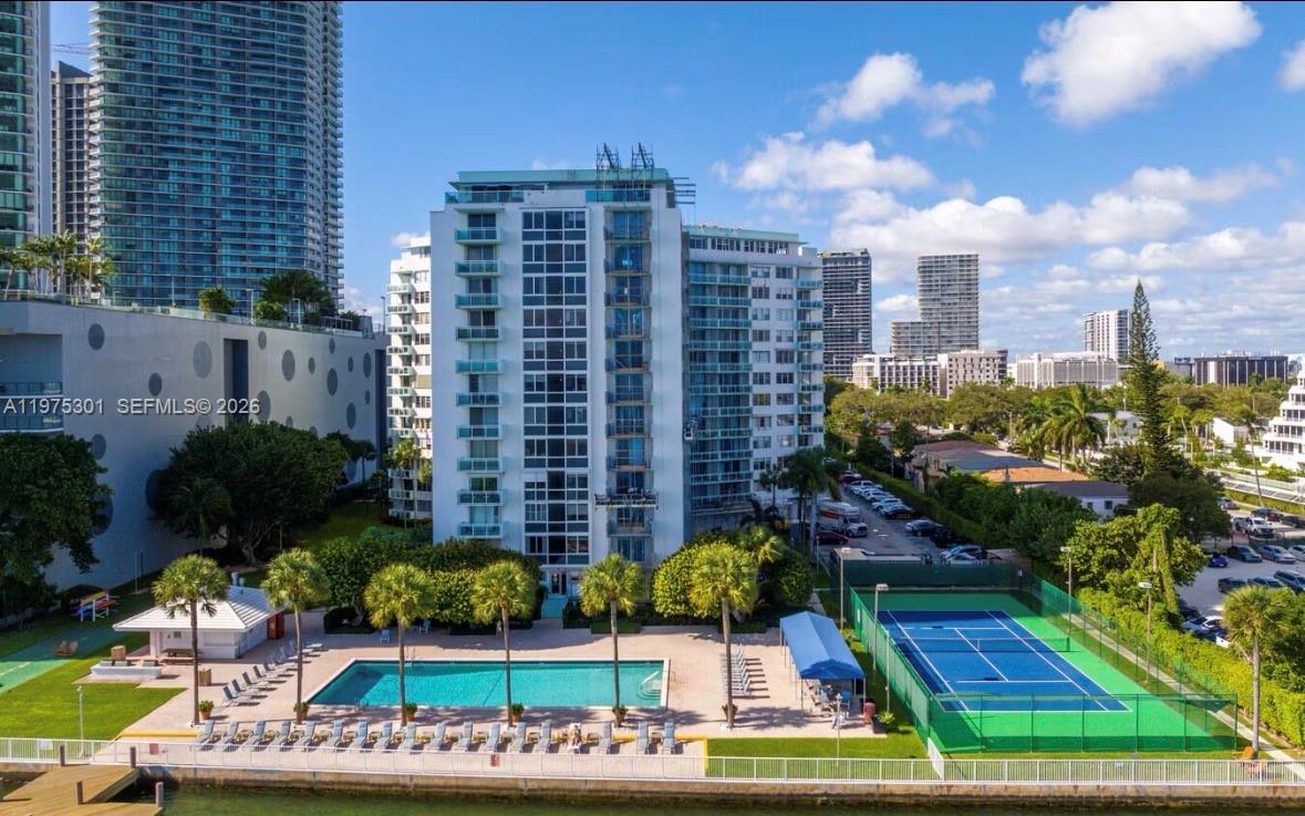 An exterior view of a residential building featuring a swimming pool and tennis court — 3301 NE 5th Ave # 519, Miami FL 33137, MIAMI, FL