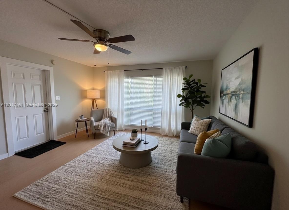 A living room features a gray sofa, a round coffee table, and a ceiling fan — 3212 NE 7th Pl # 10, Pompano Beach FL 33062, POMPANO BEACH, FL