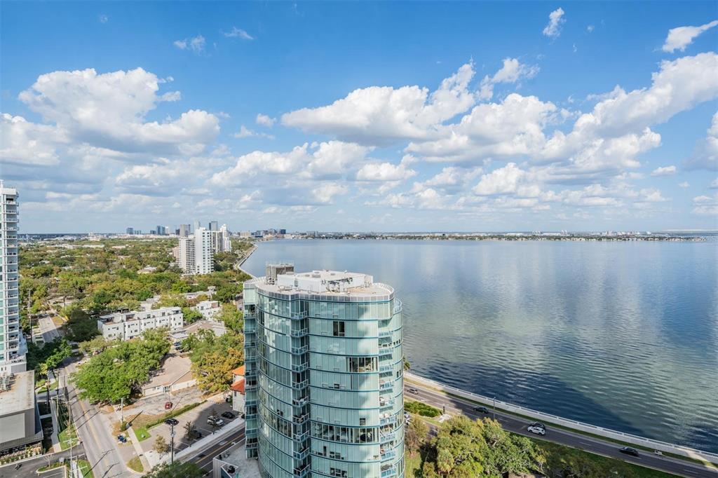 An aerial view shows a modern glass high-rise building overlooking a large bay — 3015 S YSABELLA AVENUE UNIT 2003, TAMPA, FL