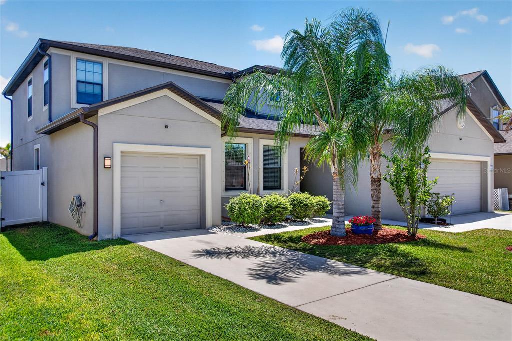 A two-story house with a two-car garage, a concrete driveway, and a palm tree — 13415 WHITE SAPPHIRE ROAD, RIVERVIEW, FL