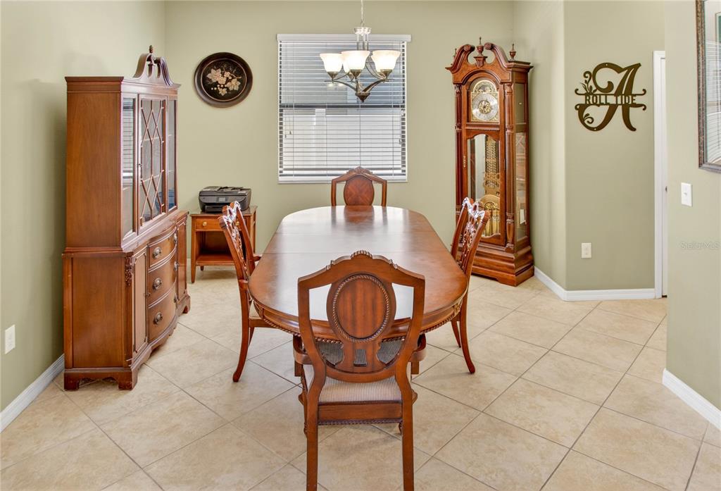 A dining room features a wooden table, chairs, a hutch, and a grandfather clock — 13415 WHITE SAPPHIRE ROAD, RIVERVIEW, FL