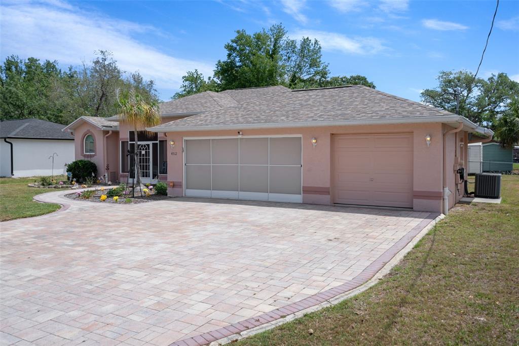 A single-story house with a pink exterior, a paved driveway, and a two-car garage — 4312 BAYRIDGE COURT, SPRING HILL, FL