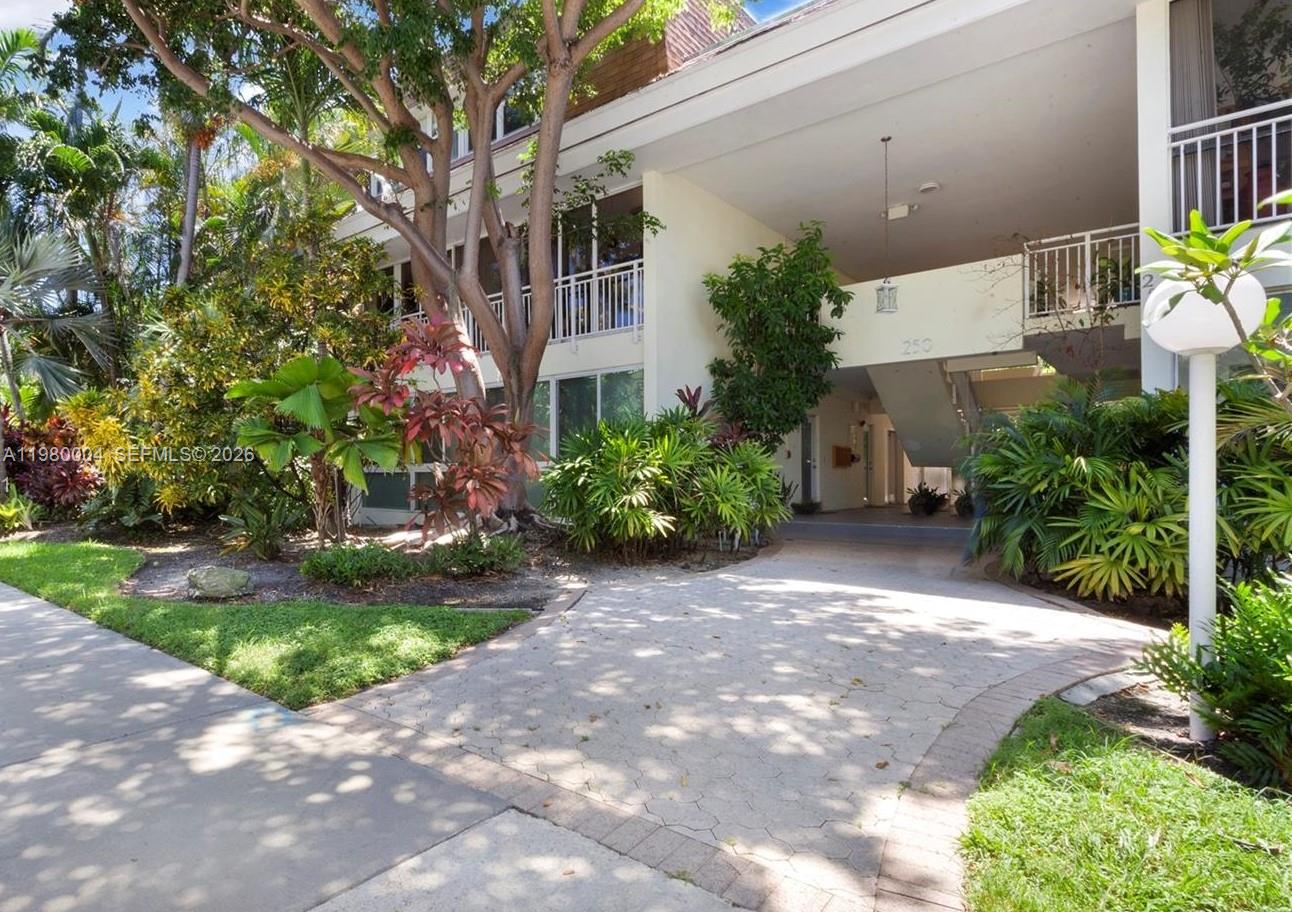The exterior of a multi-story apartment building features a paved entrance and lush tropical landscaping — 260 Sunrise Dr # H, Key Biscayne FL 33149, KEY BISCAYNE, FL