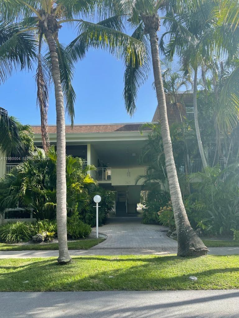 A paved walkway leads to the entrance of a two-story building framed by palm trees — 260 Sunrise Dr # H, Key Biscayne FL 33149, KEY BISCAYNE, FL