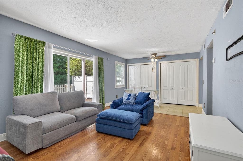 A living room features light blue walls, hardwood floors, a gray sofa, and blue seating — 2521 CEDAR CYPRESS COURT UNIT 101, TAMPA, FL