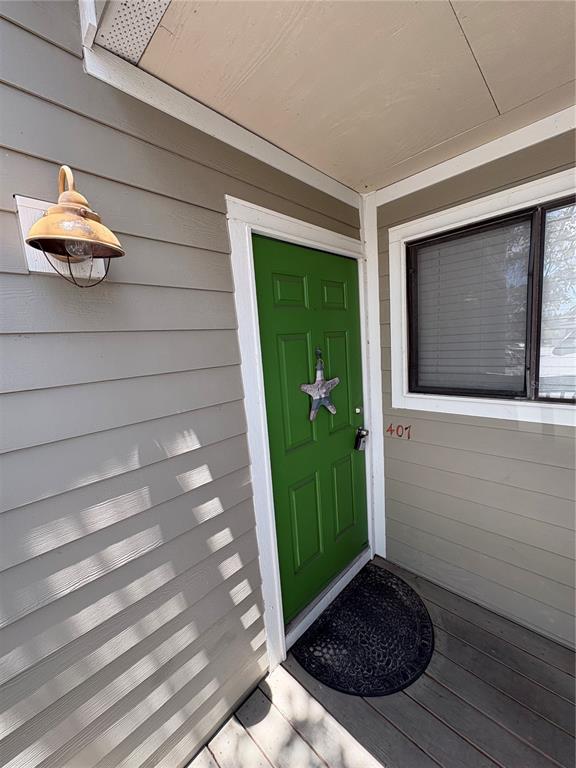 A green front door with a starfish decoration sits on a porch with gray siding — 7298 ULMERTON ROAD UNIT 407, LARGO, FL
