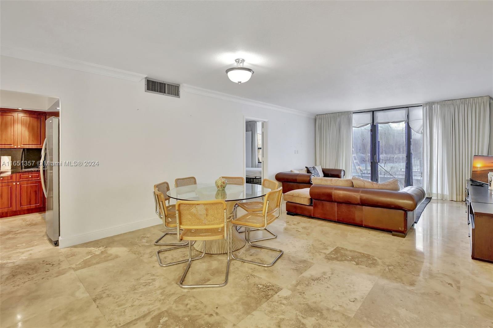 A dining area and living room feature tile floors, a glass table, and leather furniture — 9801 Collins Ave # 3T, Bal Harbour FL 33154, BAL HARBOUR, FL