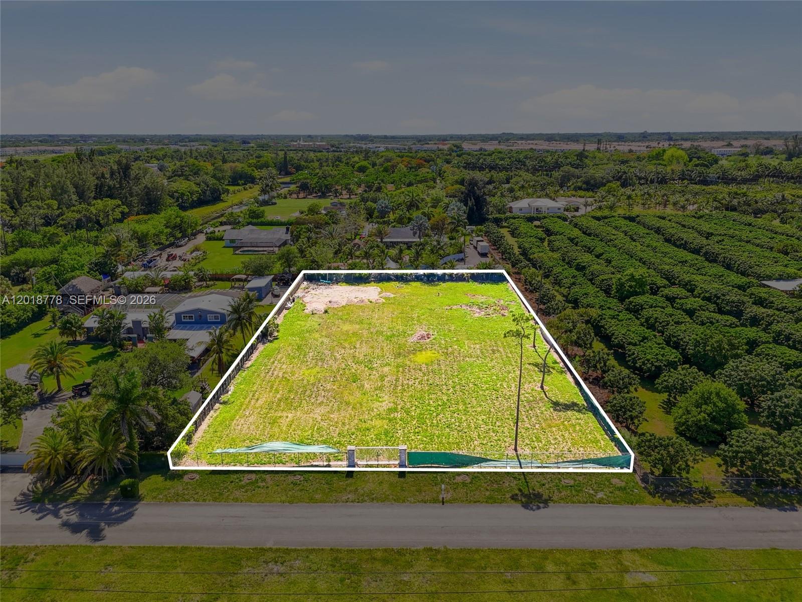 An aerial view shows a rectangular, fenced vacant lot bordered by trees and a road — 23600 SW 122 AVE, Miami FL 33032, MIAMI, FL