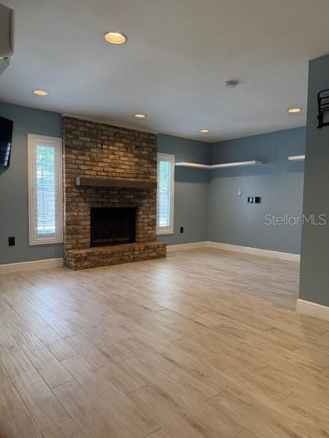 A living room features a brick fireplace, light wood-look tile flooring, and blue walls — 901 BALTIMORE DRIVE, ORLANDO, FL