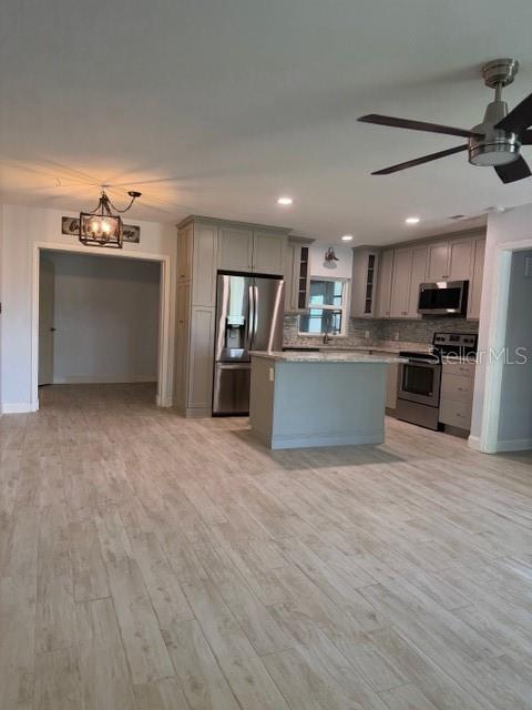 A kitchen with gray cabinets, stainless steel appliances, a center island, and light wood-look flooring — 901 BALTIMORE DRIVE, ORLANDO, FL
