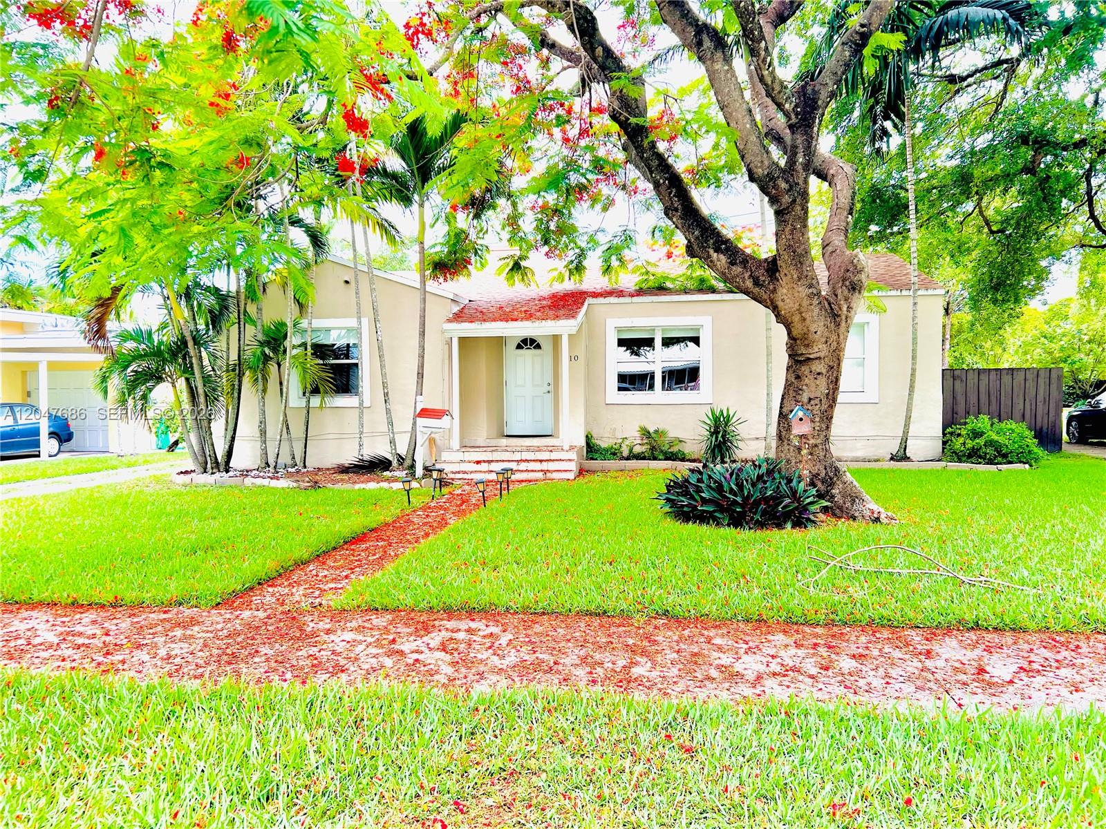 A single-story house with a white front door, a red-leafed walkway, and a large tree — 410 Pinecrest Dr # 1, Miami Springs FL 33166, MIAMI SPRINGS, FL