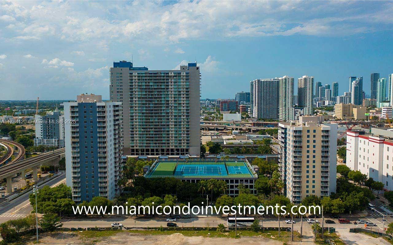 An aerial view shows several high-rise residential buildings and a tennis court in a city — 850 N Miami Ave # 2101, Miami FL 33136, MIAMI, FL