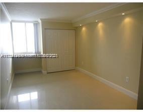 A bedroom with light-colored tile flooring, recessed ceiling lighting, and a white sliding closet door — 850 N Miami Ave # 2101, Miami FL 33136, MIAMI, FL