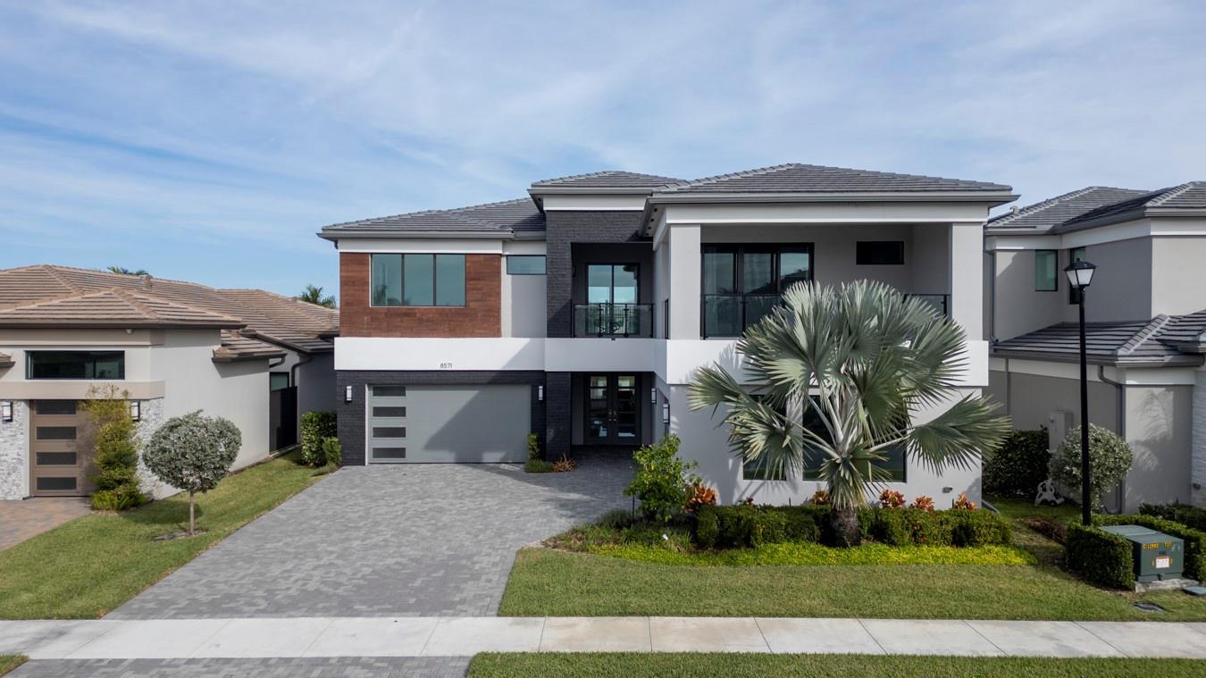 A covered balcony with light tile flooring overlooks a lake and neighboring houses — 8571 Shoreacres Street, Boca Raton FL 33434, BOCA RATON, FL