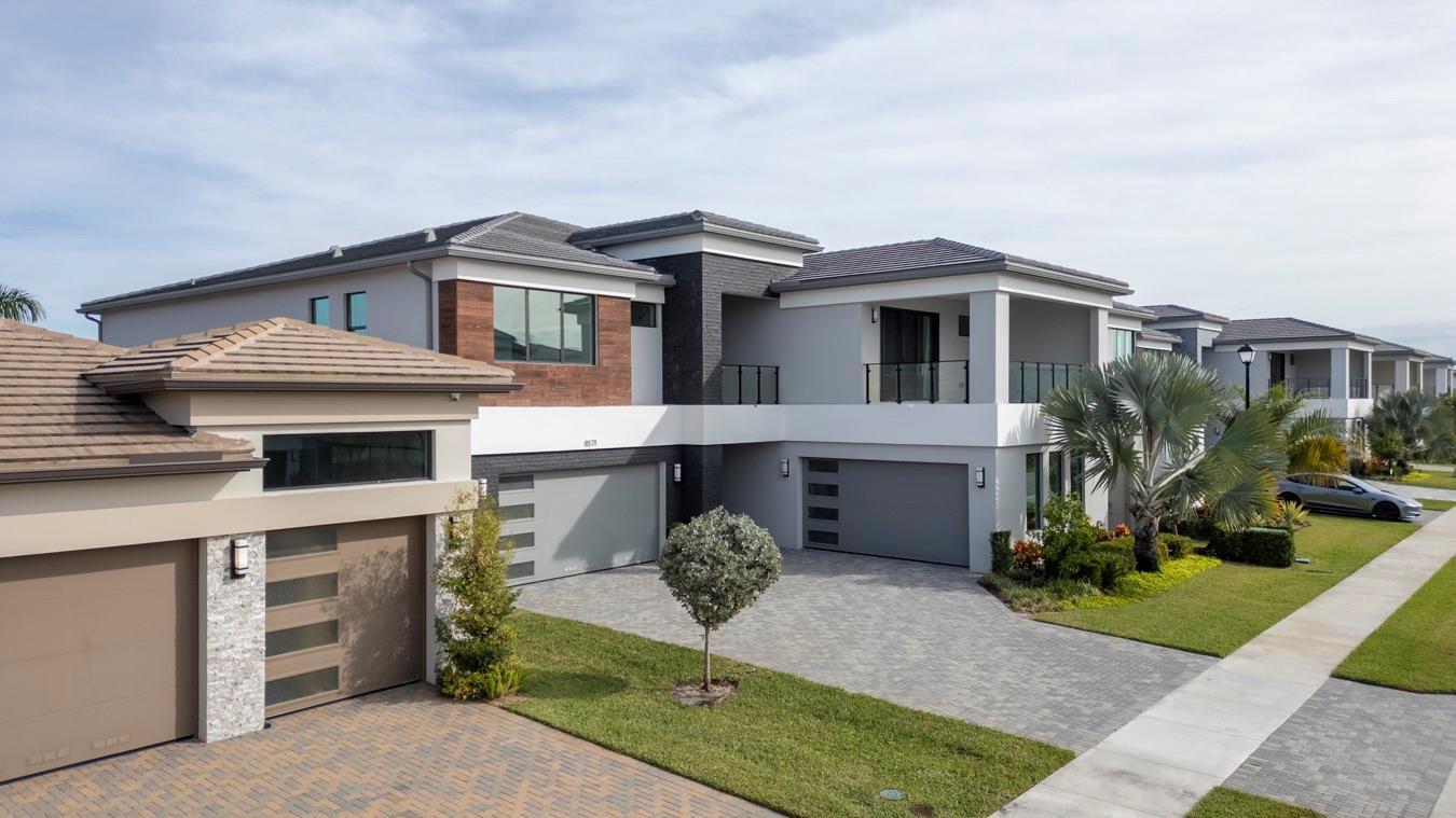 A covered patio with a glass railing overlooks a lake and residential houses — 8571 Shoreacres Street, Boca Raton FL 33434, BOCA RATON, FL