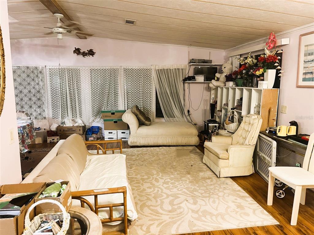A living room features a beige sofa, a chaise lounge, an armchair, and a patterned rug — 281 GOLDEN BAY BOULEVARD, OAK HILL, FL