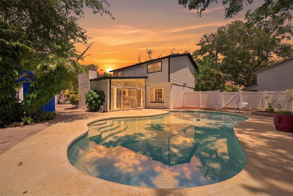 A two-story house with a backyard swimming pool and a white vinyl privacy fence — 7314 WOODKIRK COURT, TAMPA, FL