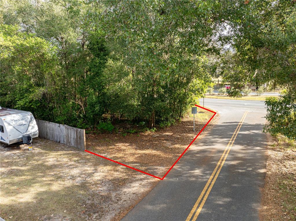 An aerial view shows a wooded lot bordered by a road and a wooden fence — SE 4TH STREET, OCALA, FL