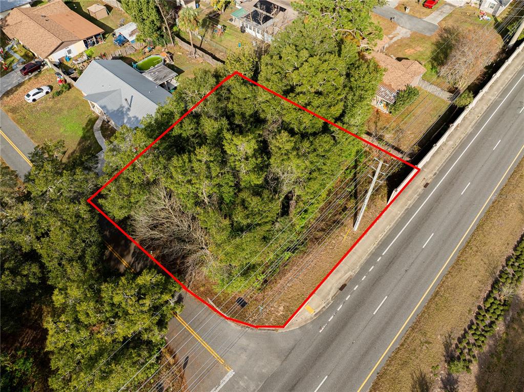An aerial view shows a wooded, rectangular vacant lot bordered by two roads — SE 4TH STREET, OCALA, FL