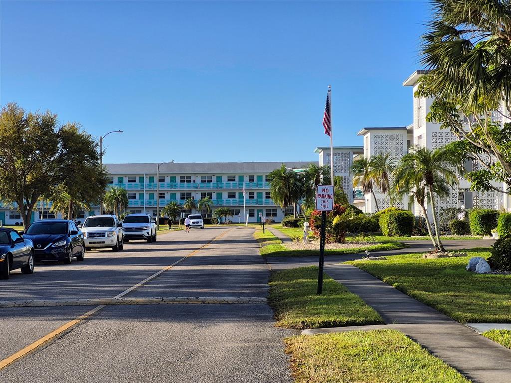 A street view shows a multi-story apartment building with a parking lot and palm trees — 6000 20TH STREET N UNIT 116, ST PETERSBURG, FL