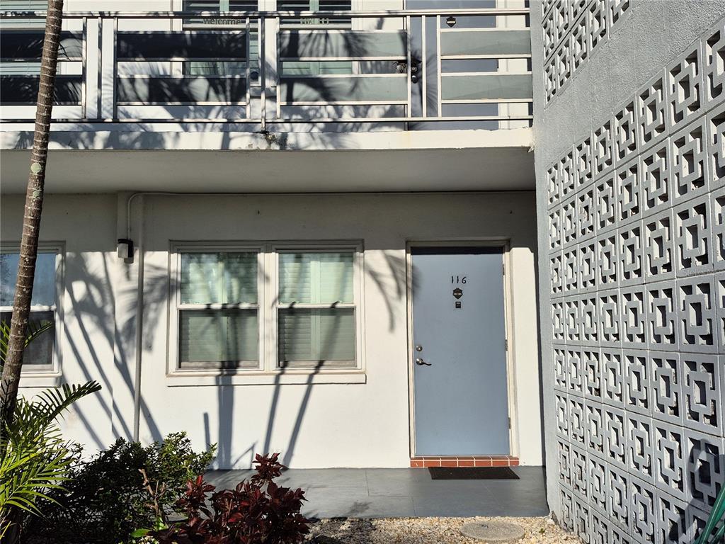 A ground-level apartment entrance features a light blue door, two windows, and decorative concrete blocks — 6000 20TH STREET N UNIT 116, ST PETERSBURG, FL