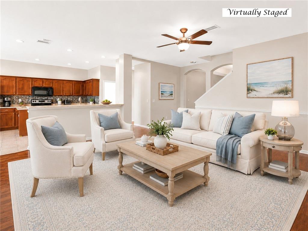 A virtually staged living room features a beige sofa, two armchairs, and a coffee table — 612 MARION HILL LANE, RUSKIN, FL
