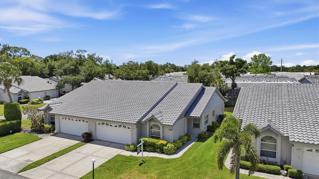 An aerial view shows two adjacent single-story houses with gray tile roofs and driveways — 5478 KELLY DRIVE UNIT 7, SARASOTA, FL