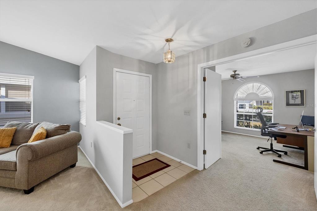 An entryway with tile flooring leads to a living area and a home office — 5478 KELLY DRIVE UNIT 7, SARASOTA, FL