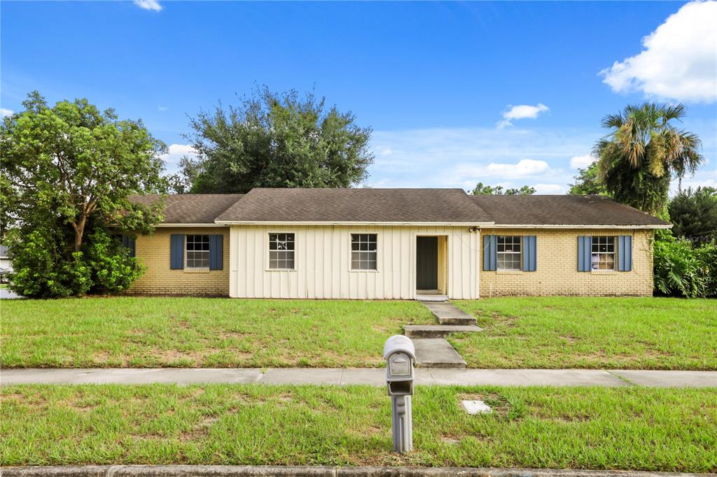 A single-story house with a brick and vertical siding exterior, blue shutters, and a lawn — 5310 NADINE STREET, ORLANDO, FL